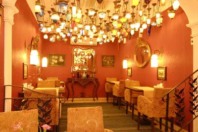 a dining room with a chandelier and tables and chairs at Kybele Hotel in Istanbul