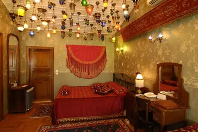 a bedroom with a bed and a table and a mirror at Kybele Hotel in Istanbul