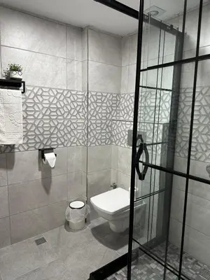 a bathroom with a toilet and a glass shower door at Hotel Estambul in Istanbul