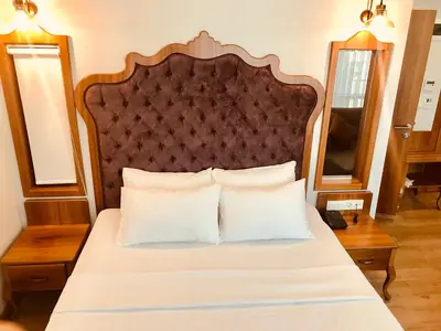 a bed with a wooden headboard and white pillows at The Meretto Hotel Istanbul Old City in Istanbul