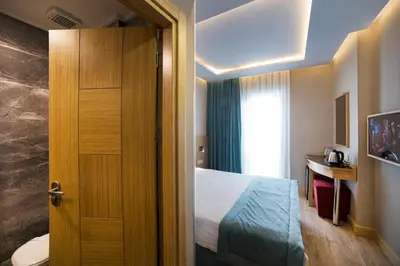 a hotel room with a bed and a door at Meretto Hotel LALELİ in Istanbul