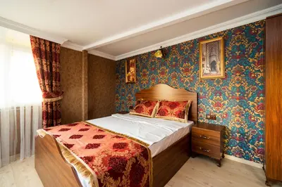 a bedroom with a bed with colorful wallpaper at The First Ottoman Suites in Istanbul