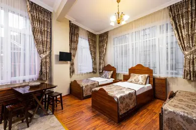 a hotel room with two beds and a table at The First Ottoman Suites in Istanbul