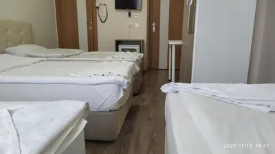 three beds in a hospital room with white sheets at Marpalace Hotel in Istanbul