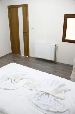 a white bed in a room with a mirror at Marpalace Hotel in Istanbul