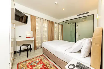 a bedroom with a bed and a desk and a television at Septimum in Istanbul