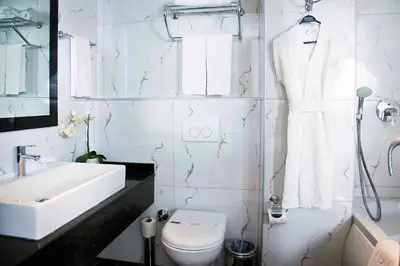 a white bathroom with a toilet and a sink at Sorriso Hotel in Istanbul