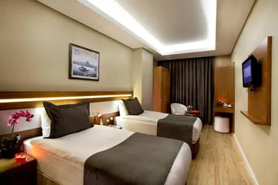 a hotel room with two beds and a television at Sorriso Hotel in Istanbul