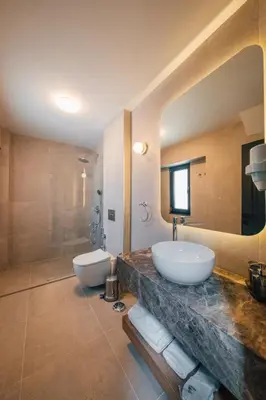 a bathroom with two sinks and a large mirror at Cevizdibi Hotel in Masukiye