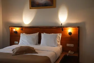 a bed in a hotel room with two lights on the wall at Cevizdibi Hotel in Masukiye