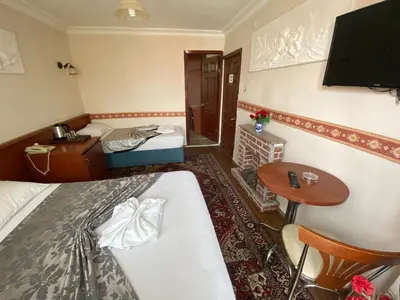 a hotel room with two beds and a table at Kadikoy Kervansaray Hotel in Istanbul