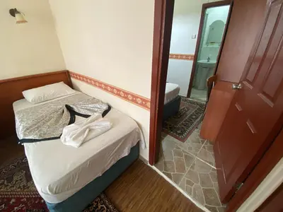 a small room with a bed and a mirror at Kadikoy Kervansaray Hotel in Istanbul