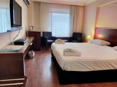 a hotel room with a bed and a desk and chairs at Tiara Thermal & SPA Hotel in Bursa