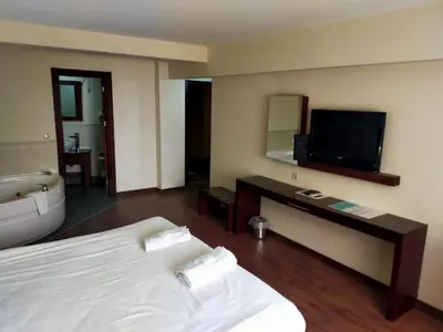 a hotel room with a bed and a tub and a television at Tiara Thermal & SPA Hotel in Bursa