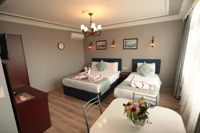 a hotel room with two beds and a table at White Pearl Apart Hotel in Istanbul