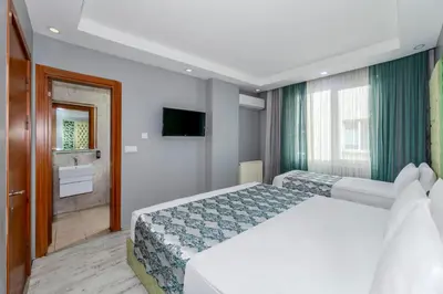 a hotel room with two beds and a television at Green Garden Hotel - Bahçelievler in Istanbul