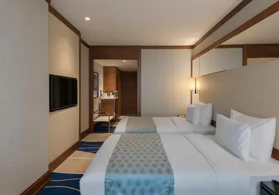a hotel room with two beds and a flat screen tv at Elite World Grand Istanbul Küçükyalı in Istanbul