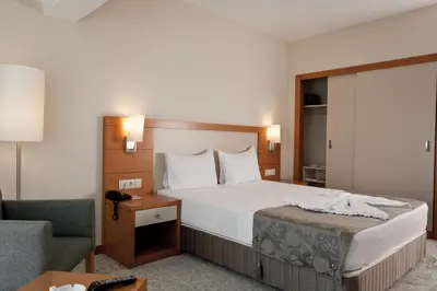 a hotel room with a bed and a chair at Mercia Hotels & Resorts in Buyukcekmece