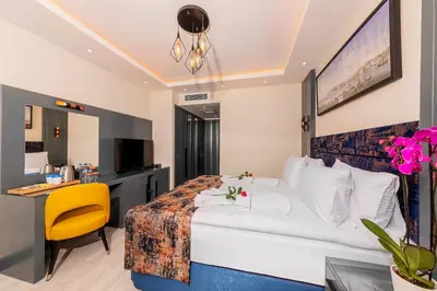 a hotel room with a bed and a desk at The Magnaura Palace Hotel in Istanbul