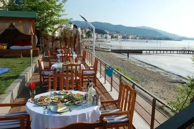 a table with plates of food sitting on top of a beach at Grand Koru Hotel Beach in Yalova