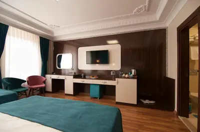 a hotel room with a bed and a tv on a wall at Akbiyik Suite Boutique Hotel in Istanbul