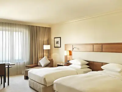 a hotel room with two beds and a desk at Grand Hyatt Istanbul in Istanbul