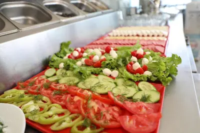 a buffet line with tomatoes cucumbers lettuce and other vegetables at Seahouse Suites in Istanbul