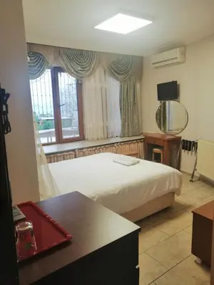 a bedroom with a bed and a desk and a window at Seahouse Suites in Istanbul