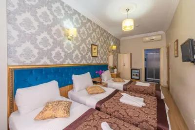a room with three beds and a couch at Ista Palace Hotel in Istanbul