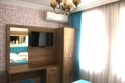 a bedroom with a tv and a mirror and a bed at Hotel Megaron in Istanbul