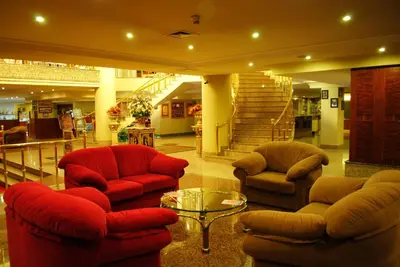 a lobby with two chairs and a table and stairs at Hotel Eken Prestige in Bandırma