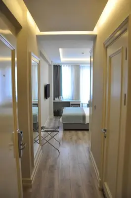 a room with a bed and a room with a mirror at Centrum Suites İstanbul in Istanbul