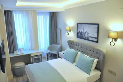 a hotel room with a large bed with blue pillows at Centrum Suites İstanbul in Istanbul