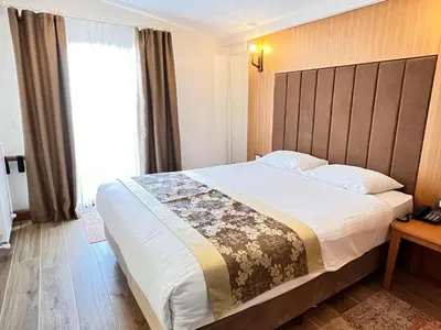 a bedroom with a large bed and a large window at Aren Suites in Istanbul