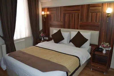 a bedroom with a large bed with white sheets and pillows at Grand Fatih Hotel in Istanbul