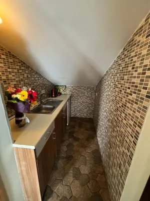 a small kitchen with a sink and a tile wall at Aycan Sultan Apart Hotel in Istanbul