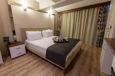 a bedroom with a bed with white sheets and pillows at Asia Business Suites in Istanbul