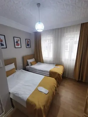 a bedroom with two beds and a chandelier at Konut Wooden House in Istanbul