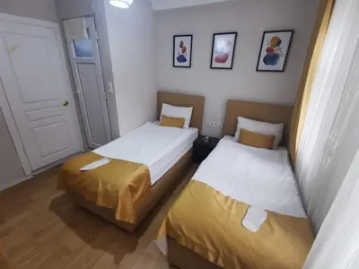 two beds in a small room with a door at Konut Wooden House in Istanbul