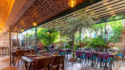 a restaurant with tables and chairs and plants at Olive Garden Apart in Istanbul