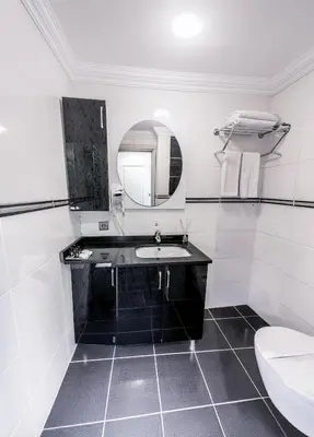 a bathroom with a sink and a mirror and a toilet at Olive Garden Apart in Istanbul