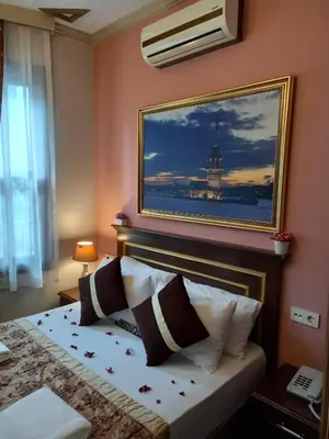 a bedroom with a bed with a painting on the wall at Emirhan Hotel, Sultanahmet in Istanbul