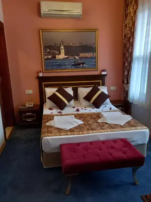 a bedroom with a large bed with a red bench at Emirhan Hotel, Sultanahmet in Istanbul