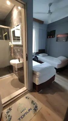 a room with two beds and a sink and a mirror at Hotel Torun Istanbul Old City in Istanbul