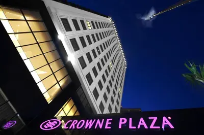 a tall building with a pink sign in front of it at Crowne Plaza Bursa Convention Center & Thermal Spa by IHG in Bursa