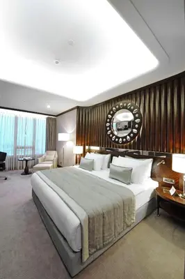 a bedroom with a large bed with a wooden wall at Crowne Plaza Bursa Convention Center & Thermal Spa by IHG in Bursa