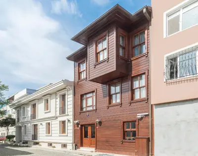 a wooden building in front of two white buildings at Lalinn Hotel in Istanbul