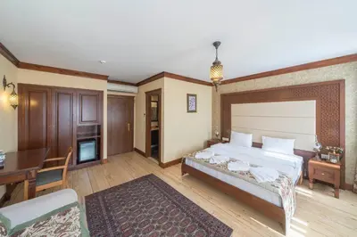 a bedroom with a bed and a table and a desk at Lalinn Hotel in Istanbul