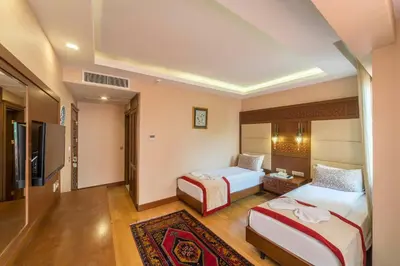 a hotel room with two beds and a television at Lalinn Hotel in Istanbul