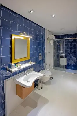 a blue tiled bathroom with a sink and a toilet at Nowy Efendi Hotel - Special Category in Istanbul